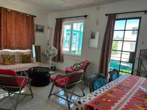 a living room with chairs and tables and windows at Villas Floralies in Grand-Baie