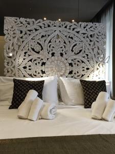 a bedroom with a white bed with a large headboard at 29 Venti Luxury in Palermo