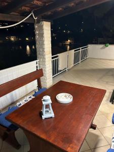 a wooden table on a balcony with a plate on it at Apartment Dino in Splitska