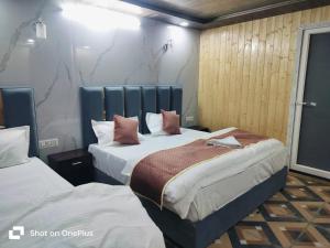 two beds in a hotel room with two beds at Silver Dew Resorts and Restaurant in Dhanaulti