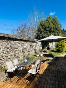 a patio with a table and chairs and an umbrella at La Chambre de l'Atelier -Larchant in Larchant