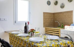 La Mansarda sul Verde في شاكا: طاولة عليها صحون واكواب في مطبخ +4 صور