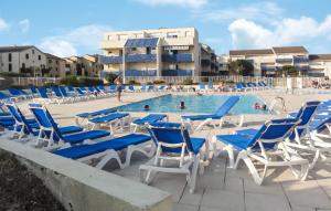 una piscina con sedie e persone blu e bianche di Pet-Friendly Apartment In Lacanau a Lacanau