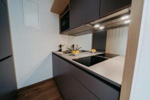 a kitchen with black and white counters and cabinets at RELAX APARTMENTS An der Lage Hochgraßnitzberg in Spielfeld