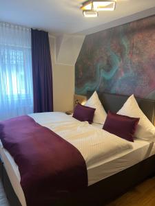 a bedroom with a bed with a large painting on the wall at Hotel Restaurant Wolfsschlucht GmbH in Bad Münstereifel