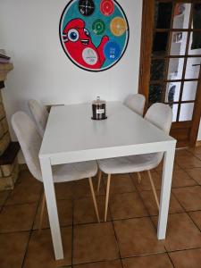 a white table and chairs with a plate on the wall at Maison entiere avec Terrasse proche A1 CDG Asterix in Saint-Witz