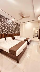 ein Schlafzimmer mit zwei Betten und einem Wandbild in der Unterkunft Hotel Garden Palace in Mumbai