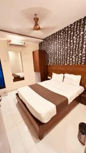 ein Schlafzimmer mit einem Bett und einem Fernseher darin in der Unterkunft Hotel Garden Palace in Mumbai