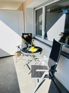 a balcony with a glass table and two chairs at Fewo Saur in Immenstaad am Bodensee +2 photos