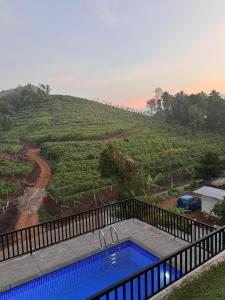a swimming pool with a view of a hill at KiwiOz Villa in Thamarassery