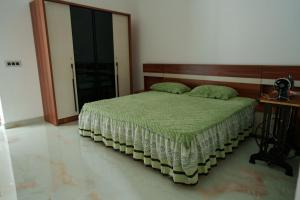a bedroom with a bed with a wooden headboard at KiwiOz Villa in Thamarassery +30 photos