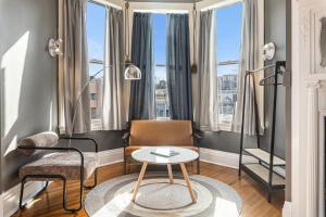 a living room with a table and chairs and windows at Hassinger Daniels Guest House in Birmingham