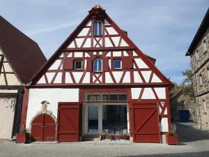 een rood-wit gebouw met een gambrel dak bij Scheunenromantik Altstadt in Forchheim