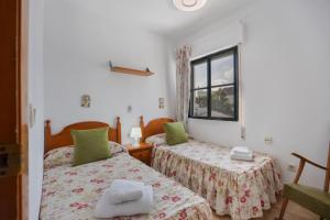 a room with two beds and a window at Apto Unifamiliar Dos Dormitorios in Chiclana de la Frontera +18 photos
