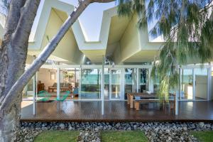 an open living room with glass walls and a house at Florida Beach House I Private Properties in Dawesville
