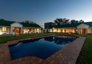 une maison avec une piscine en face d'une maison dans l'établissement Trumpetters Drift Game Farm, à Grahamstown