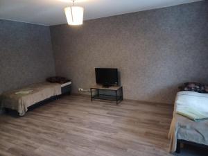 a room with two beds and a flat screen tv at Myllymäki 22 X in Lahti