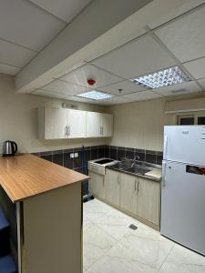 an empty kitchen with a white refrigerator and a counter at المهاجرين فرع الحزام in Medina +27 photos