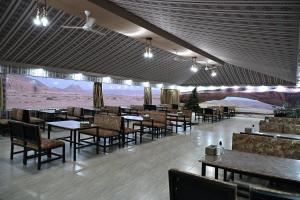 a restaurant with tables and chairs and a view of the desert at Bilal luxury camp in Disah