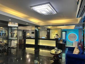 ein Wohnzimmer mit einem blauen Sofa und einem Tisch in der Unterkunft Fortuna Hotel in Bangkok