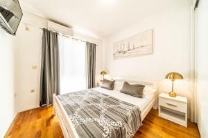 Un dormitorio blanco con una cama y una ventana. en Apartments Spalato, en Podstrana
