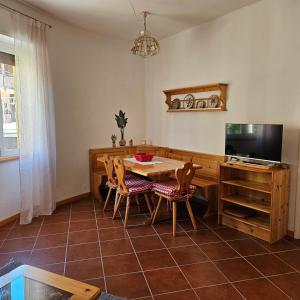 a dining room with a table and a television at a 2 passi dal lago in Oliveto Lario