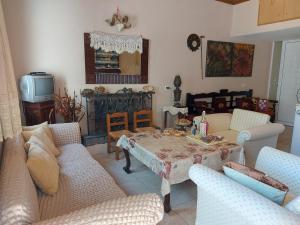 a living room with a table and chairs and a tv at Villa Maria in Roussakianá