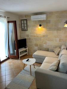 a living room with a couch and a tv at Apartment Dino in Splitska