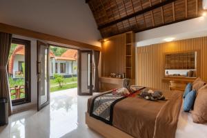 a bedroom with a bed and a large window at Bintang Bungalow in Nusa Penida +70 photos