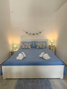a bedroom with a blue bed with towels on it at La Casa del mare in Syracuse