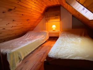 2 łóżka w pokoju z drewnianym sufitem w obiekcie Marmotte Gîte 2à4 personnes avec cheminée à 10mn des pistes w mieście Aragnouet