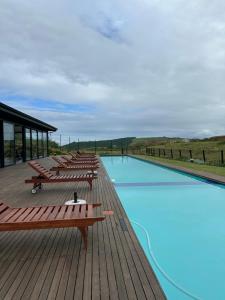 una fila de bancos sentados en una terraza junto a una piscina en Vista Zimbali, en Ballito
