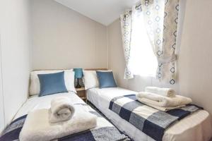 two beds in a room with towels on them at Hope View - Ashbourne Heights Holiday Park in Fenny Bentley +5 photos