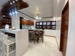 a kitchen with a bar with chairs and a table at Aloha - Your Stylish City Escape in Gate