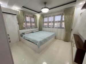 a bedroom with a bed and two windows at Aloha - Your Stylish City Escape in Gate +4 photos