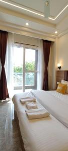 una camera da letto con un letto grande con una grande finestra di Lime Tree 1BHK Service Apartment Near Fortis Hospital Gurgaon a Gurgaon