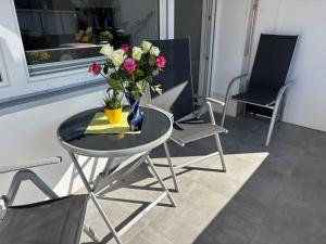 a glass table with a vase of flowers on it at Fewo Saur in Immenstaad am Bodensee