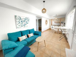 un soggiorno con un divano blu e una cucina di Apartamentos Marinera I y II a Cotillo