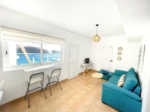 un soggiorno con un divano e sedie blu di Apartamentos Marinera I y II a Cotillo