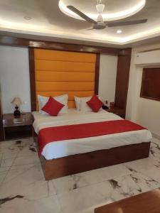 a bedroom with a large bed with red pillows at Royal Park - Hotels & Resorts in Ghaziabad