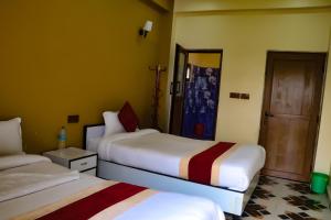 Tempat tidur dalam kamar di Hotel Flycatcher Chitwan- A jungle Safari Home