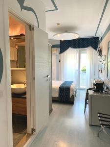 a bedroom with a bed and a bathroom with a sink at Meublè Tripoli in Grado +34 photos