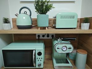 a microwave and a toaster on a wooden shelf at Central Greatforest Apartman 2 in Debrecen