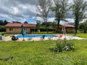 a backyard with a swimming pool and a house at Ô Village in Giromagny