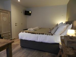 a bedroom with a large bed with white sheets and pillows at B&B De Swaenhoeck in Damme