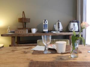 B&B De Swaenhoeck في دام: طاولة مع آلة صنع القهوة على طاولة مع آلة صنع القهوة