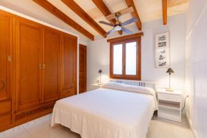 a bedroom with a white bed and a ceiling fan at Clarona in Cala en Blanes