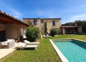 a villa with a swimming pool in front of a house at Les Terrasses - Gordes in Gordes