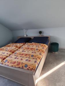 a bed with a comforter on it in a bedroom at Ferienwohnung Hartmann in Wernigerode