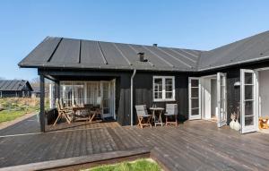 a black house with a deck and a table at 3 Bedroom Cozy Home In Nysted in Nysted +9 photos